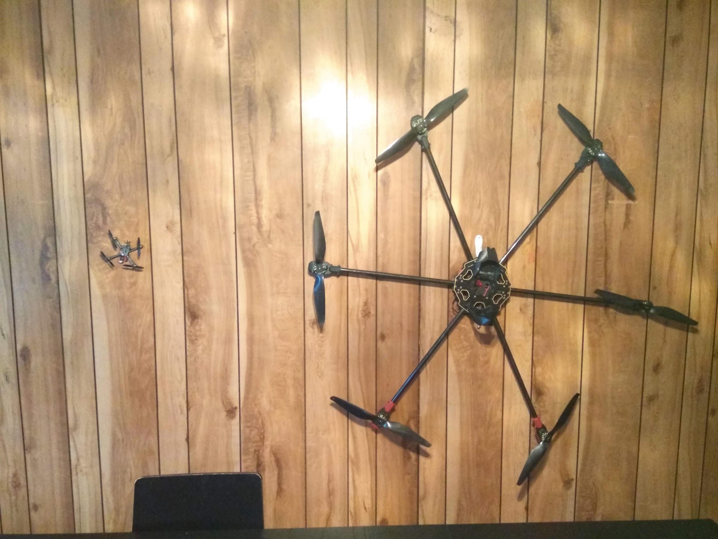 Drone chassis as a wall decoration, next to a 90mm drone for scale.