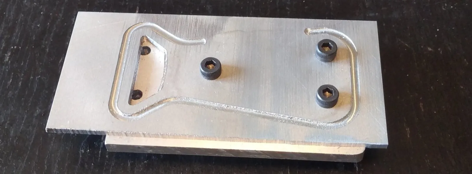The fixture, with an interrupted piece in operation 3. The M5 bolts are screwed into holes tapped into the fixture, and are snugly fitting the 5mm bores in the piece.